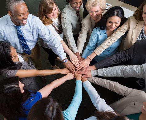 Diverse team of professionals with hands in teamwork huddle - GMS ...