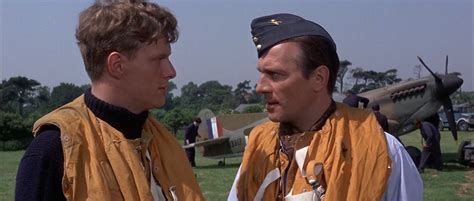 two men standing next to each other in front of an airplane