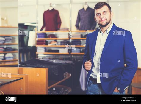 happy french man choosing casual jacket in fashion store Stock Photo ...