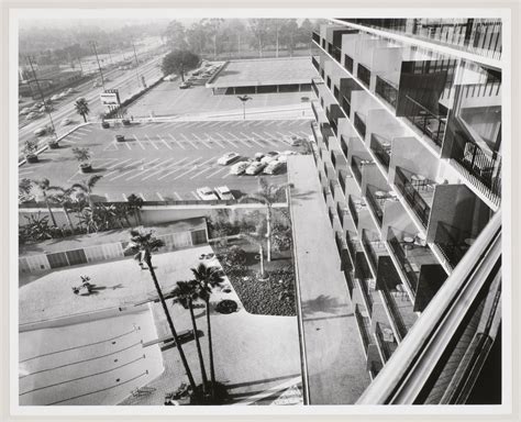 Partial view of the façade, parking lot, and pool at the Beverly Hilton ...