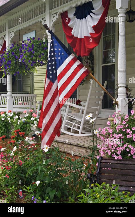 American Flag and Patriotic Bunting on Porch of Victorian Cottage with ...