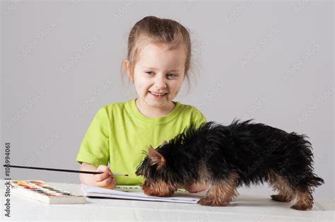 Little girl drawing with a puppy Stock Photo | Adobe Stock