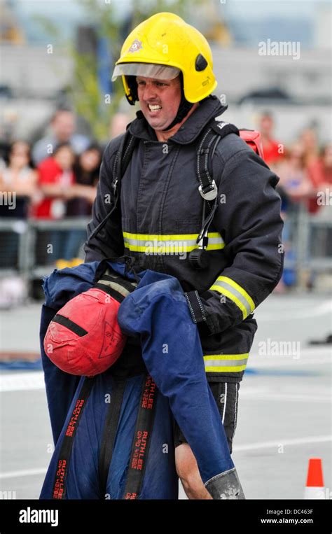 Belfast, Northern Ireland. 8th August 2013 - A fireman drags a heavy ...