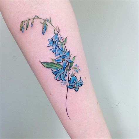 a blue flower tattoo on the arm