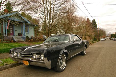 OLD PARKED CARS.: 1967 Oldsmobile Cutlass Supreme.