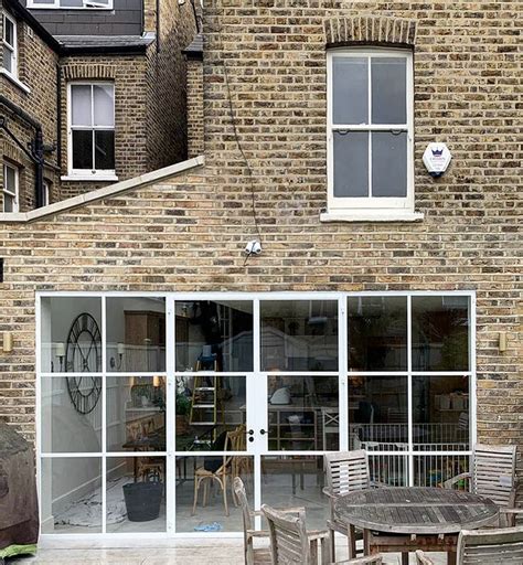 an outside patio with tables and chairs in front of a brick building ...