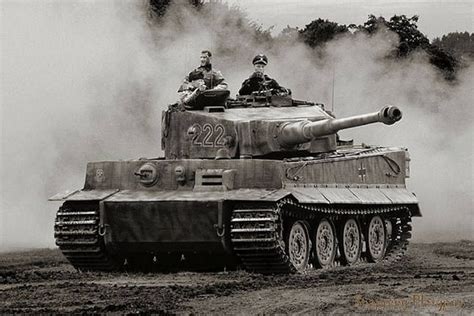 two men are riding on top of a tank