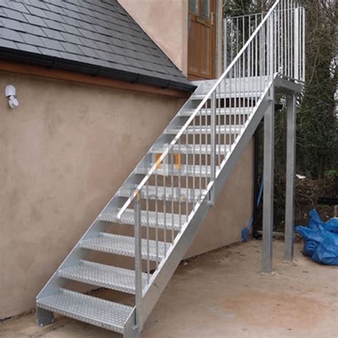 a metal stair case next to a house