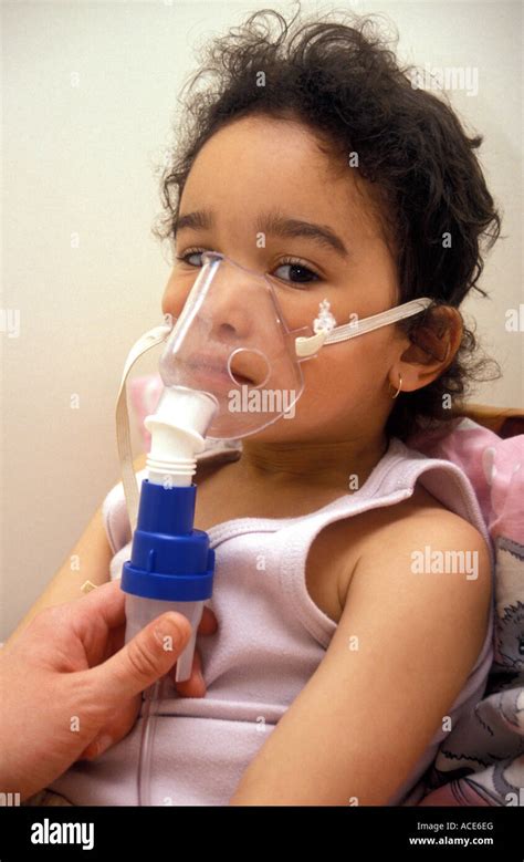 mixed race girl aged around 5 being administered salbutamol for asthma ...