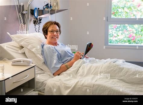 Woman smiling on hospital bed Stock Photo - Alamy