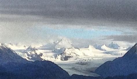 the mountains are covered in snow and clouds