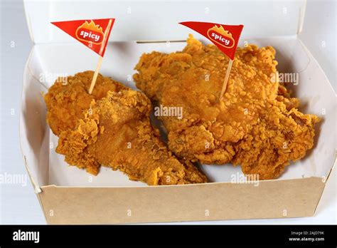 A Jollibee "Chickenjoy!" 2-piece spicy fried chicken in a paper take ...