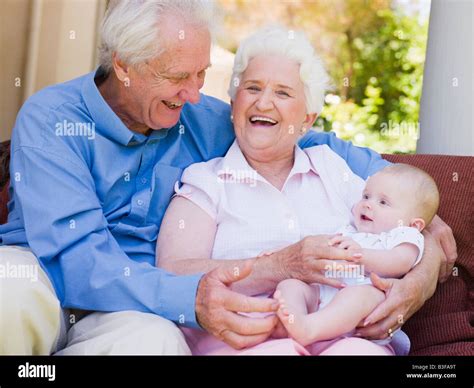 Grandparents outdoors on patio with baby smiling Stock Photo - Alamy