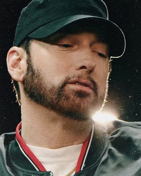 a close up of a person wearing a baseball cap and earring necklace with ...