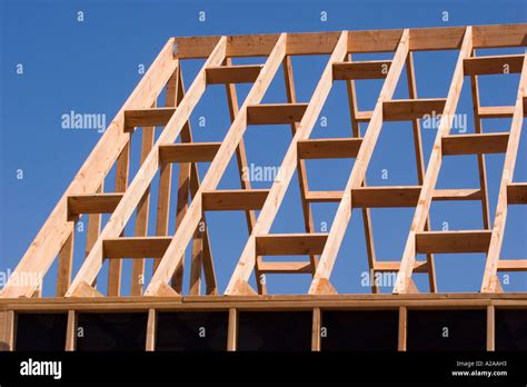 A small house under construction, showing the roof joists against a ...