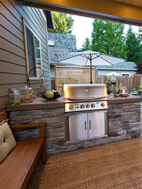 an outdoor kitchen with grill and seating area