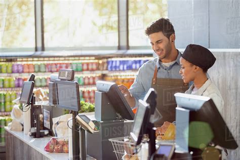 Cashiers working at grocery store checkout - Stock Photo - Dissolve