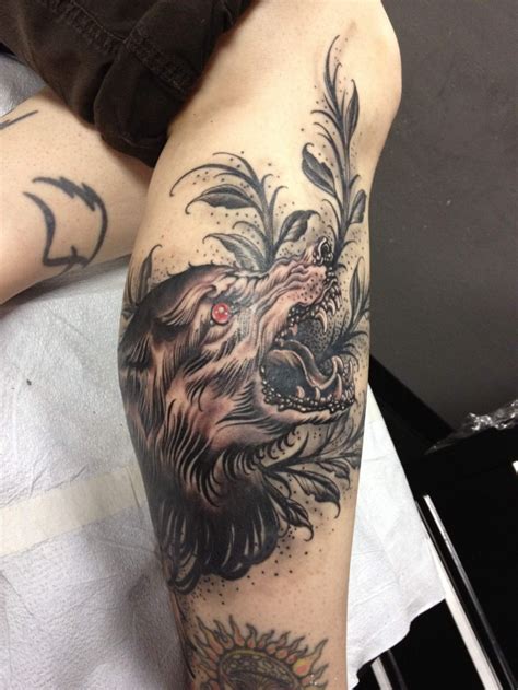 Engraving style colored leg tattoo of demonic wolf with plants ...