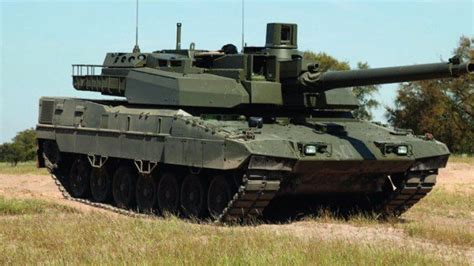 an army tank sitting on top of a grass covered field