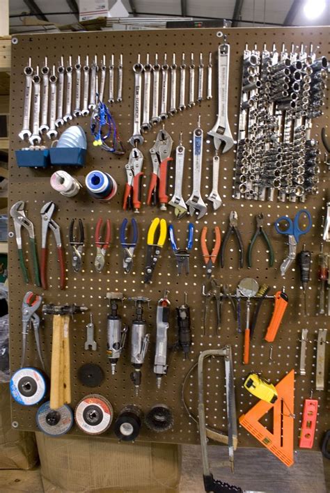 there are many tools hanging on the pegboard in this workshop area ...