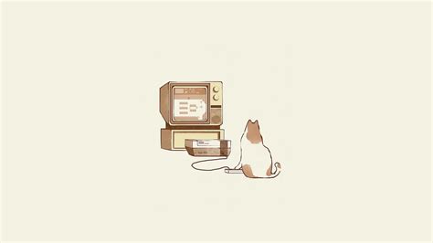 a cat sitting next to two old cell phones