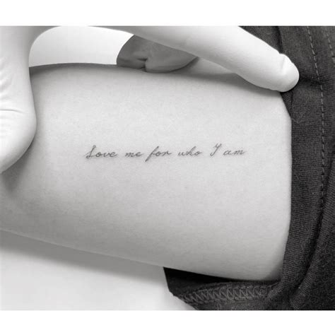 "Love me for who I am" lettering tattoo located on the