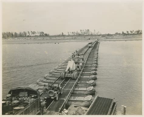 Convoy of artillery and vehicles move across pontoon bridge over Po ...