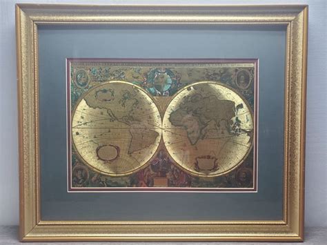 two framed maps in a gold frame on a wall