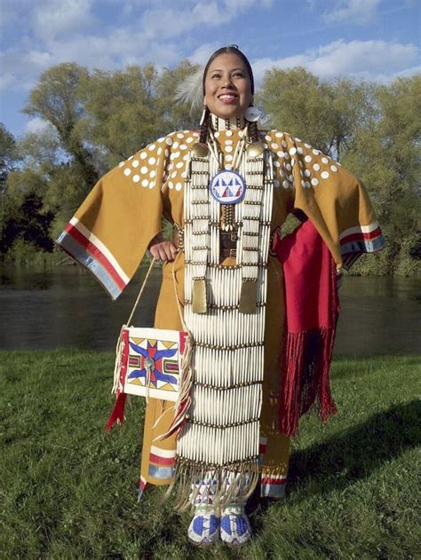 a woman dressed in native american clothing posing for the camera