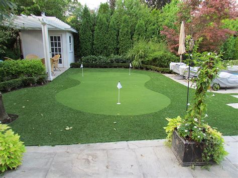 nicely shaped golf green surrounded by articial landscape grass poolside