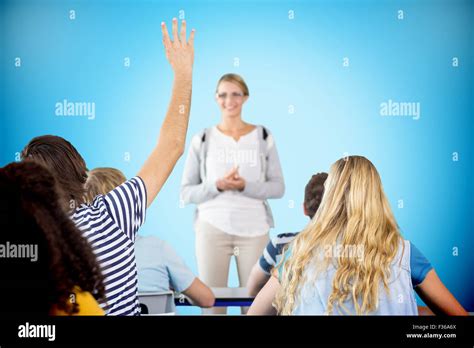 Composite image of student raising hand in classroom Stock Photo - Alamy