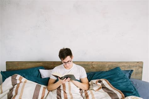 Premium Photo | Man reading a book on his bed at home