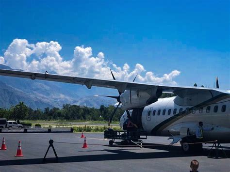 an airplane is parked on the tarmac with people around it