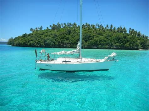 White boat floating in clear body of water near island during day time ...