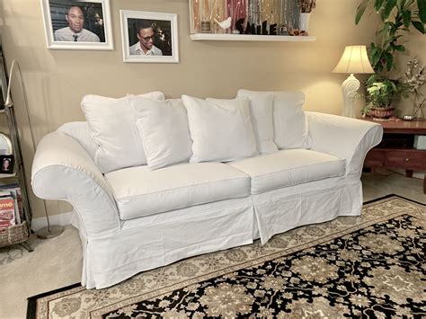 a white couch sitting on top of a rug in a living room