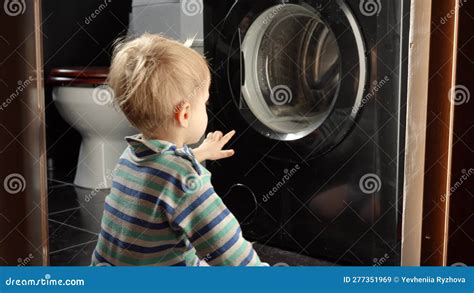 Cute Smiling Baby Boy Looking at Spinning Clothes in Washing Machine ...