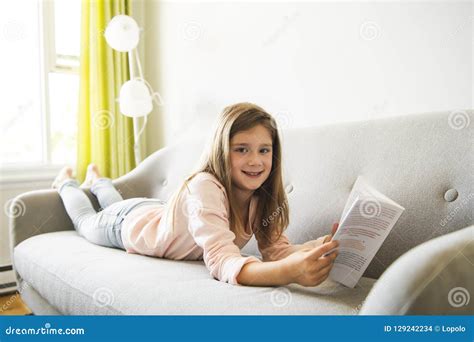 Girl Reading Book on Sofa in Living Room at Home Stock Photo - Image of ...