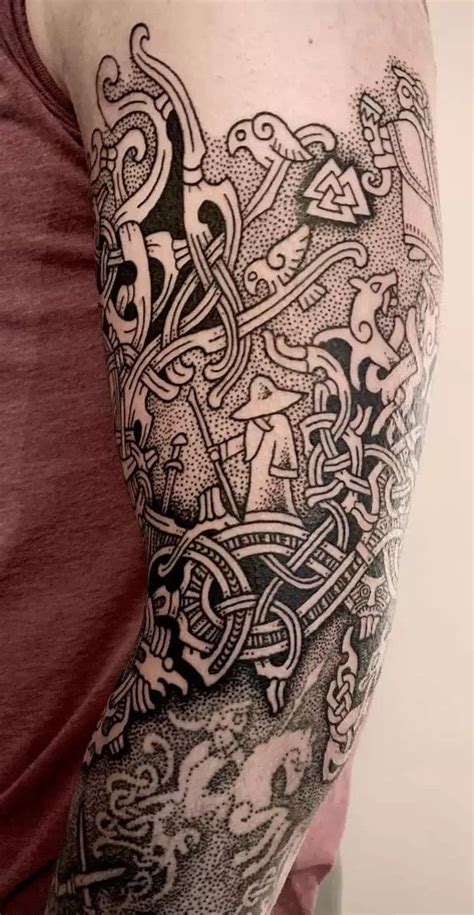 a man's arm with an intricate tattoo design on the arm and shoulder,