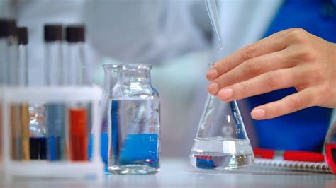 Chemical reaction in lab flask. Close up of female chemist hands doing ...