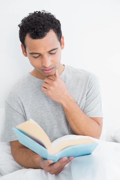 Premium Photo | Serious relaxed man reading book in bed