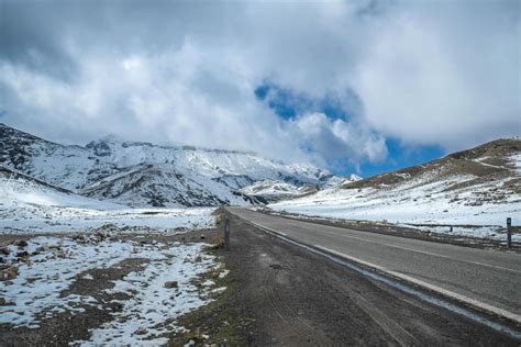 A road amid snow capped mountain range 1228004 Stock Photo at Vecteezy