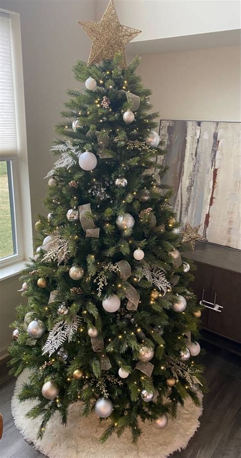 a decorated christmas tree in the corner of a room with a large window ...