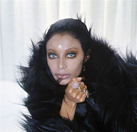 a woman with blue eyes and black fur coat