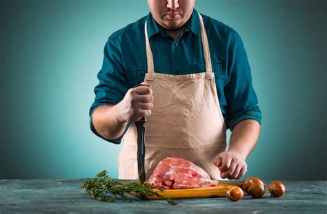 Butcher cutting pork meat on kitchen | Free Photo