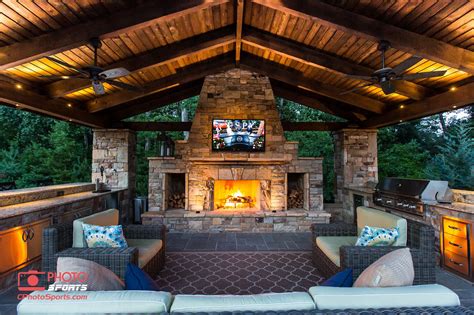 A pavilion with an outdoor kitchen, fireplace and an entertainment ...