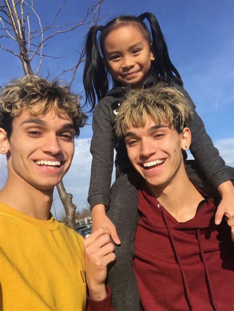 two boys and a girl are smiling for the camera