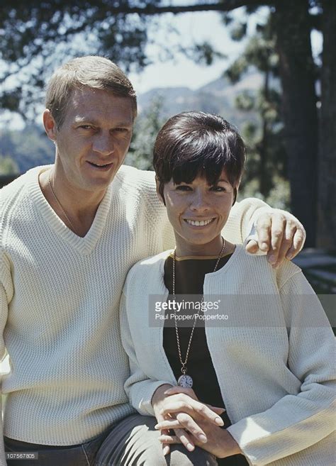 a man and woman sitting next to each other in the grass, smiling at the ...