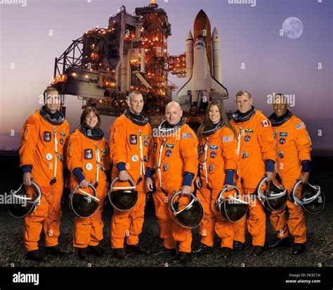 Group portrait of the STS-118 space shuttle crew astronauts in orange ...