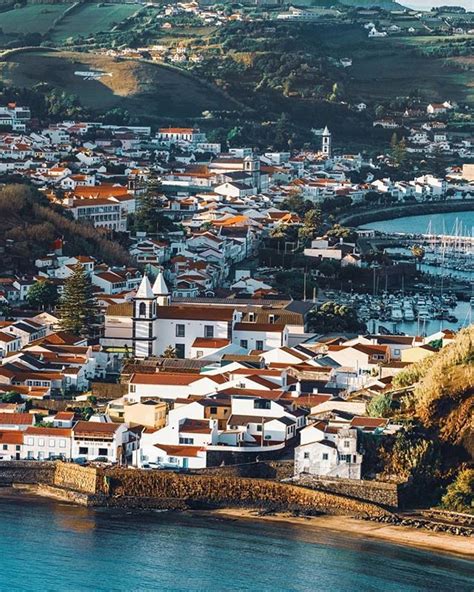 an aerial view of a city by the water with lots of houses and boats in it