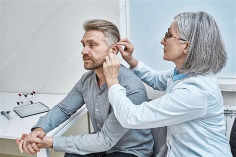 Hearing aid fitting - Stock Image - F037/4958 - Science Photo Library